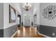 Bright foyer featuring hardwood floors, chandelier, wainscoting, and decorative wall art at 1377 Downington Nw Ln, Acworth, GA 30101