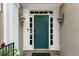 Inviting teal front door with sidelights and elegant white trim, framed by sconce lighting at 1377 Downington Nw Ln, Acworth, GA 30101