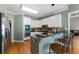 Open-concept kitchen features a breakfast bar, stainless steel appliances, granite counters, and hardwood floors at 1377 Downington Nw Ln, Acworth, GA 30101