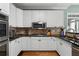 Well-equipped kitchen with white cabinets, stainless steel appliances, granite countertops, and tiled backsplash at 1377 Downington Nw Ln, Acworth, GA 30101