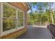 Brick home with stained back deck, dark railings, and lush trees at 1750 Providence Place Dr, Alpharetta, GA 30009