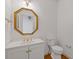 Elegant powder room with octagon mirror, classic white vanity, and complementary gold fixtures at 1750 Providence Place Dr, Alpharetta, GA 30009