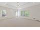 Spacious bedroom with neutral carpet, bright windows, and a tray ceiling with a ceiling fan at 1750 Providence Place Dr, Alpharetta, GA 30009
