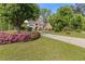 Beautiful brick home with a large front lawn, flowering bushes, and a concrete driveway at 1750 Providence Place Dr, Alpharetta, GA 30009