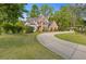 Charming two-story brick home with mature trees and a concrete driveway at 1750 Providence Place Dr, Alpharetta, GA 30009