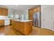 This kitchen features natural wood cabinets, hardwood floors, stainless steel refrigerator, and island gas range at 1750 Providence Place Dr, Alpharetta, GA 30009