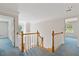 This bright landing features wooden banisters and is illuminated by a hanging light fixture at 1750 Providence Place Dr, Alpharetta, GA 30009