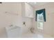 This laundry room features white cabinets, a utility sink, a window, and tile floors at 1750 Providence Place Dr, Alpharetta, GA 30009