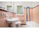 Vintage-style bathroom with sink, toilet, bathtub and pink tiling at 2714 Laurel Ridge Dr, Decatur, GA 30033