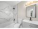 A bathroom featuring a combination shower and tub with marble tile and gray vanity at 5401 Martins Crossing Rd, Stone Mountain, GA 30088