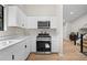 Bright kitchen features white cabinets, stainless steel appliances and wood-look floors at 5401 Martins Crossing Rd, Stone Mountain, GA 30088