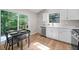 Bright kitchen with white cabinets, modern appliances, and a dining area with backyard view at 5401 Martins Crossing Rd, Stone Mountain, GA 30088