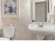 Charming powder room with pedestal sink, elegant wallpaper, and decorative accents at 960 Lost Forest Dr, Sandy Springs, GA 30328