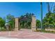 Abernathy Greenway entrance featuring brick columns and a wrought iron sign, surrounded by lush greenery and manicured landscaping at 960 Lost Forest Dr, Sandy Springs, GA 30328