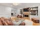 Inviting living room with stone fireplace, built-in shelving, and plush leather seating area at 960 Lost Forest Dr, Sandy Springs, GA 30328