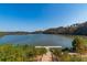 Scenic water view from the property, featuring a dock, natural landscaping and lush greenery surrounding the lake at 960 Lost Forest Dr, Sandy Springs, GA 30328