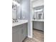 Modern bathroom with gray cabinets, white countertops, and wood-look floors at 947 Summer Forest Drive, Suwanee, GA 30024