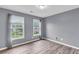 Well-lit bedroom with two windows and hardwood flooring at 947 Summer Forest Drive, Suwanee, GA 30024