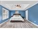 Bright blue bedroom features a tray ceiling, large windows, and wood-look flooring at 947 Summer Forest Drive, Suwanee, GA 30024