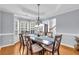 Elegant dining room with tray ceiling, wainscoting, and bay window overlooking the yard at 947 Summer Forest Drive, Suwanee, GA 30024