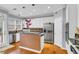 Bright kitchen features stainless steel appliances, white cabinetry, and hardwood flooring at 947 Summer Forest Drive, Suwanee, GA 30024