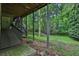 View of the backyard, showing a covered deck with stairs, and lush trees at 747 Mill Rock St, Lawrenceville, GA 30044