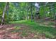 Lush, green backyard featuring a multilevel deck surrounded by mature trees at 747 Mill Rock St, Lawrenceville, GA 30044