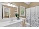 Bright bathroom with white vanity, framed mirror, and a shower with decorative shower curtain at 747 Mill Rock St, Lawrenceville, GA 30044