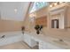 Bathroom with double vanity, garden tub, granite counters, and a picture window at 747 Mill Rock St, Lawrenceville, GA 30044