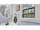 Bright bathroom featuring a white vanity, circular mirror, and a window with natural light at 747 Mill Rock St, Lawrenceville, GA 30044