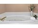 Close up view of a bathtub with white tiling and gold fixtures at 747 Mill Rock St, Lawrenceville, GA 30044