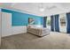 Bedroom with blue accent wall, large windows, neutral carpet, and a light colored bed at 747 Mill Rock St, Lawrenceville, GA 30044