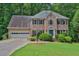 Charming two-story brick home with a manicured lawn and a two-car garage nestled among mature trees at 747 Mill Rock St, Lawrenceville, GA 30044