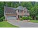 Charming two-story brick home with a manicured lawn and a two-car garage nestled among mature trees at 747 Mill Rock St, Lawrenceville, GA 30044