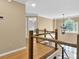 Upstairs hallway featuring a wood railing, hanging light fixture, and a view to the front entrance at 747 Mill Rock St, Lawrenceville, GA 30044