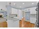 Open kitchen with island, white cabinets, and seamless flow to living area at 747 Mill Rock St, Lawrenceville, GA 30044