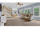 Comfortable living room featuring a sofa and staircase, illuminated by natural light from the windows at 747 Mill Rock St, Lawrenceville, GA 30044