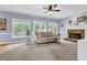 Comfortable living room featuring neutral tones, large windows, and a stone fireplace at 747 Mill Rock St, Lawrenceville, GA 30044