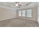 Spacious bedroom with a tray ceiling, ceiling fan, and large windows at 1300 Hopkins Dr, Decatur, GA 30033