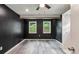 Bedroom with dark walls, two windows, ceiling fan, and grey wood-look flooring at 232 Apple Branch Dr, Woodstock, GA 30188