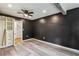 Bedroom with dark walls, two windows, ceiling fan, grey wood-look flooring, and built-in closet at 232 Apple Branch Dr, Woodstock, GA 30188