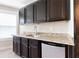 A bar area has a granite counter top, wood cabinets and drawers, and a small refrigerator at 411 Ridgeway Ln, Canton, GA 30114