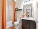 This beautiful bathroom offers an orange colored shower curtain and dark wood cabinets at 411 Ridgeway Ln, Canton, GA 30114