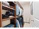 A walk-in closet has dark wood shelves and rods for clothing and is well-organized at 411 Ridgeway Ln, Canton, GA 30114
