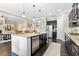 Modern kitchen featuring an island with seating and stainless steel appliances that opens to the living room at 411 Ridgeway Ln, Canton, GA 30114