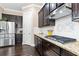 Well-equipped kitchen with stainless appliances, dark cabinets, granite counters, tile backsplash and ample counterspace at 411 Ridgeway Ln, Canton, GA 30114