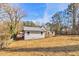 The back of the home is shown with a big lawn, gray vinyl siding, and black roof at 204 Elm St, Palmetto, GA 30268