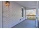 Cozy porch with whitewashed brick wall, stylish light fixture, and a glimpse of the natural outdoor scenery at 204 Elm St, Palmetto, GA 30268