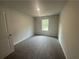 Comfortable bedroom with neutral walls, soft carpeting, and a view of exterior at 35 Yellow Brick Way, Covington, GA 30014