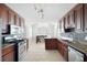 Bright kitchen features stainless steel appliances, dark wood cabinetry, and adjacent dining area at 6275 Cheatham Lake Nw Dr, Acworth, GA 30101